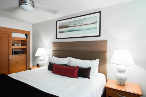 Un pat sau paturi într-o cameră la West Coast Suites at UBC