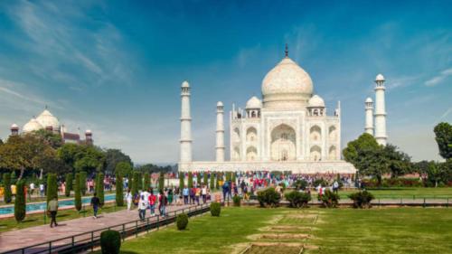 un grupo de personas caminando delante del taj mahal en The NoVo Agra, en Agra