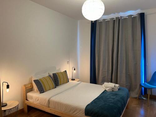 a bedroom with a large bed and a blue chair at Ramona in Aveiro