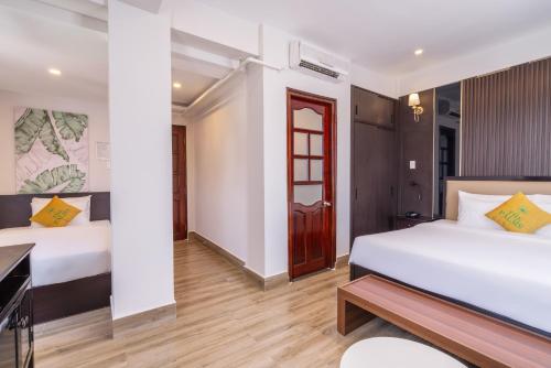 Pokój hotelowy z 2 łóżkami i biurkiem w obiekcie The Palms Hotel Phan Thiết w mieście Phan Thiet