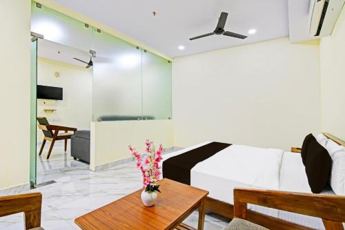 Super Townhouse Dwarakanagar Near Gurudwara في Raspari Palao: غرفة نوم بسرير وطاولة عليها ورد