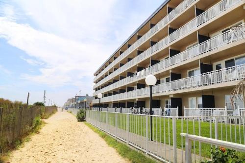 um edifício na praia ao lado de uma cerca em Dunes Suites Oceanfront em Ocean City