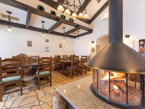 a fireplace in a restaurant with a tables and chairs at Tabist Shizukuishi Resort Hotel in Shizukuishi