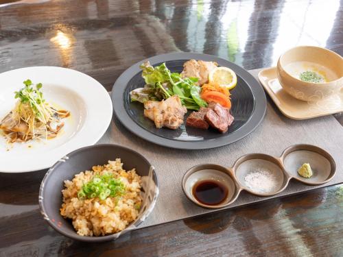 a table with two plates of food with rice and vegetables at Tabist Shizukuishi Resort Hotel in Shizukuishi