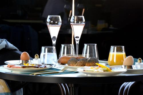 einen Tisch mit Teller mit Speisen und Gläsern Wein in der Unterkunft sgrafit hotel - Self Check-In in Retz