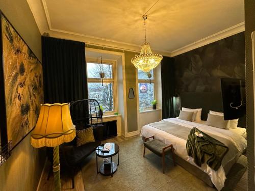 Schlafzimmer mit einem Bett und einem Kronleuchter in der Unterkunft Hotell Onyxen, boutique- & lifestyle, Adults Only in Göteborg