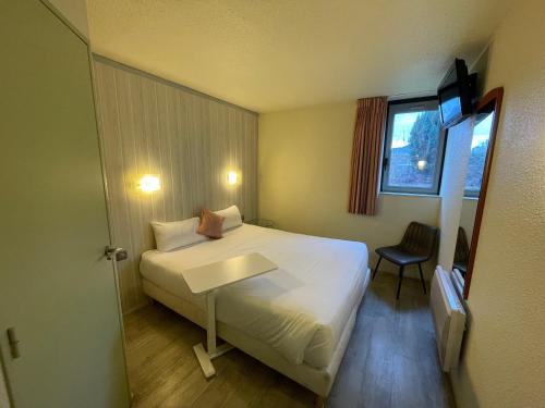 um quarto de hotel com uma cama e uma janela em Brit Hotel Chambery em Chambéry