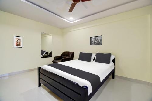 ein Schlafzimmer mit einem Bett und einem Stuhl darin in der Unterkunft Super Hotel O Murali Nagar Near NAD Junction in Visakhapatnam