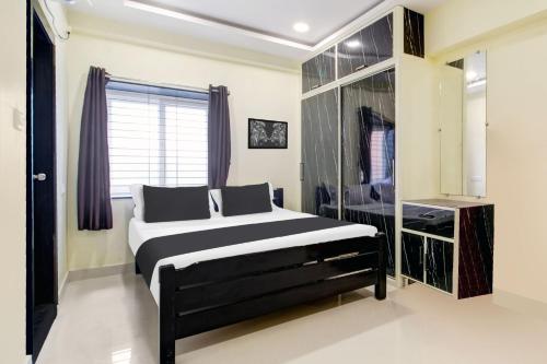 Schlafzimmer mit einem schwarzen und weißen Bett und einem Fenster in der Unterkunft Super Hotel O Murali Nagar Near NAD Junction in Visakhapatnam