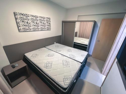 Dormitorio pequeño con cama y espejo en Equilibrio Park Veredas Flat- Rio Quente Goiás, en Rio Quente