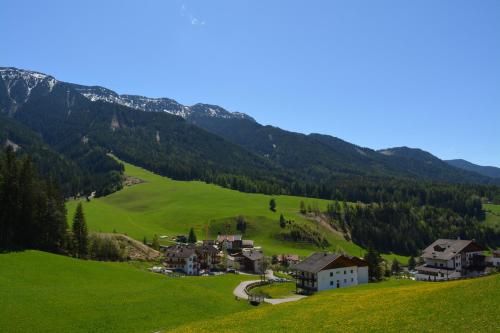 a small village in a green valley with mountains at Fallerhof in Villnoss