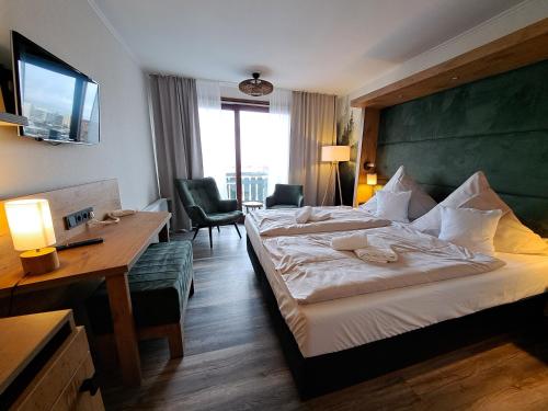 een hotelkamer met een groot bed, een bureau en een bureau bij Hotel Wernerwald in Cuxhaven