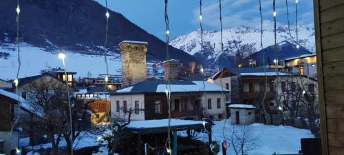 vista su una città nella neve di notte di Hotel Svanseti a Mestia