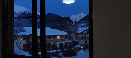 una vista da una finestra di una città con montagne innevate di Hotel Svanseti a Mestia