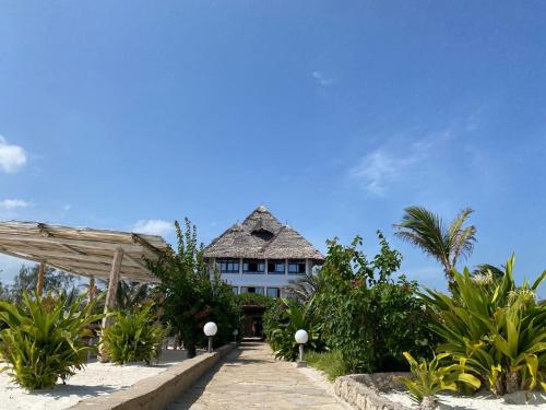 une maison sur la plage avec des palmiers dans l'établissement Nuru Room at Lulu Beach, à Watamu