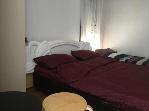 Schlafzimmer mit einem Bett mit einer roten Bettdecke und einem Tisch in der Unterkunft Rooms Struga in Struga