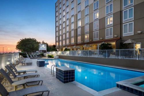 una piscina de hotel con tumbonas junto a un edificio en DoubleTree by Hilton Hotel Biloxi, en Biloxi