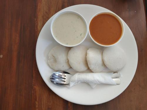 einen Teller mit zwei Schalen Suppe und einer Gabel in der Unterkunft Hsquare Hotel Andheri West in Mumbai