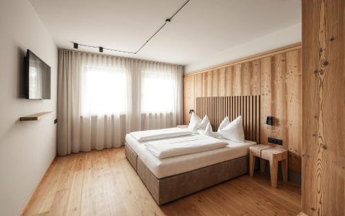 a bedroom with a large bed and a window at Apartment Lodge Gasserhof in Bressanone