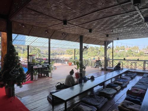 un grupo de personas sentadas en un banco en un edificio en Funny Riverside Backpackers, en Luang Prabang