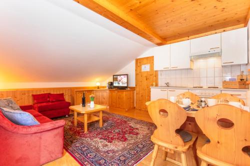 uma sala de estar com um sofá vermelho e uma cozinha em Sonnberg Lodge em Maria Alm am Steinernen Meer