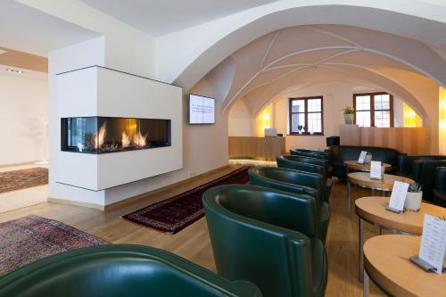 ein Wartezimmer mit Stühlen und einem Kamin in der Unterkunft Hotel Maximilian - Stadthaus Penz in Innsbruck