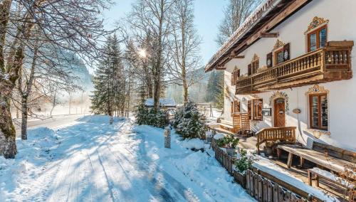 una casa con la neve per terra davanti di Die Bäckeralm a Bayrischzell