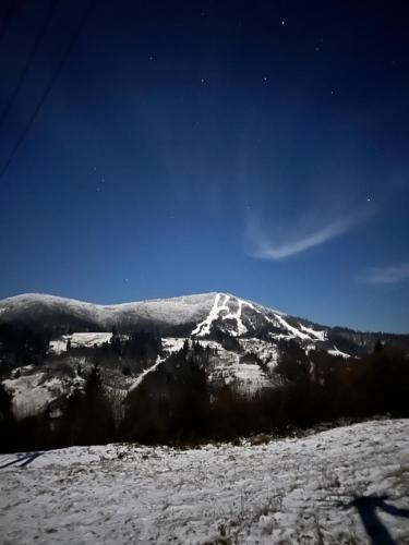 een berg met sneeuw erop met een blauwe lucht bij Under Sky Slavske - Котеджі з приватним чаном-джакузі, панорамною ванною та PlayStation 5 in Slavske