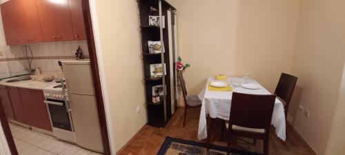 uma cozinha com uma mesa e uma cozinha com um lavatório, uma mesa e cadeiras em Apartman Gala Beograd em Belgrado