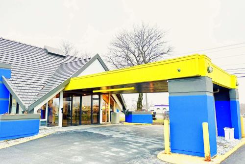 un negozio di fronte con un edificio giallo e blu di Days Inn by Wyndham Rutland/Killington Area a Rutland