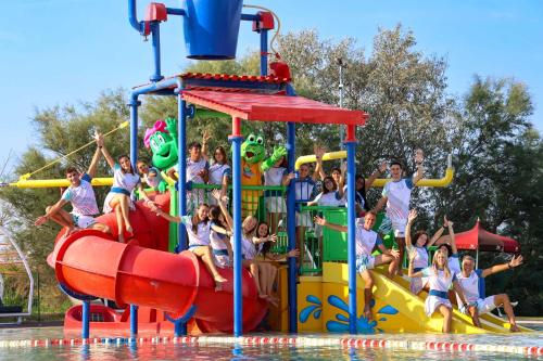 un grupo de niños jugando en un tobogán acuático en un parque acuático en Camping Village Capalonga, en Bibione