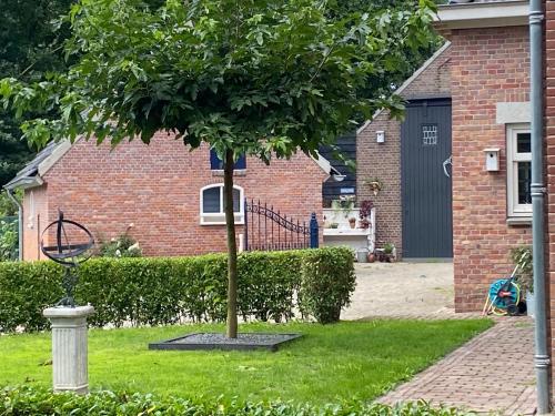 a tree in a yard in front of a house at B & B In Two Hulten in Hulten