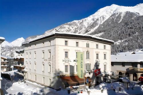 een hotelherberg met een met sneeuw bedekte berg op de achtergrond bij Hotel Acla Filli in Zernez