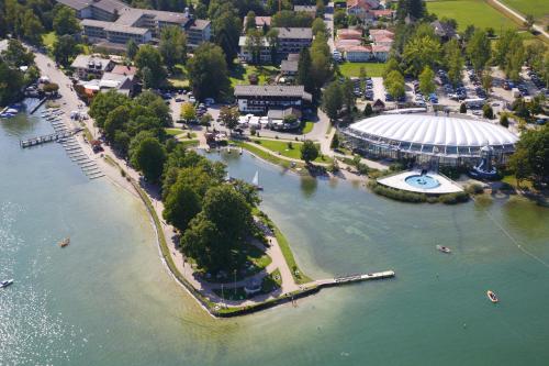 Hotel Schlossblick Chiemsee في برين أم كيمزيه: اطلالة جوية على نهر مع مبنى في الماء