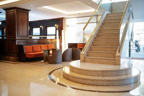 eine Lobby mit einer Treppe und einem Sitzbereich in der Unterkunft Amérian Buenos Aires Park Hotel in Buenos Aires