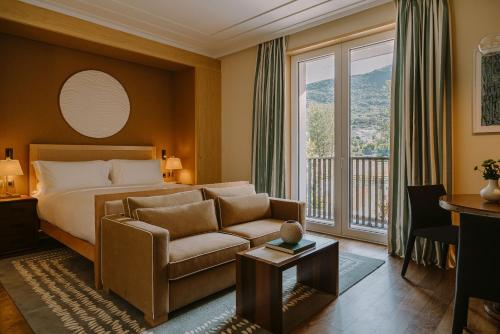 Regent Porto Montenegro في تيفات: غرفه فندقيه بسرير واريكه