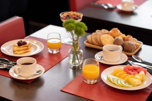 una mesa con platos de comida y tazas de zumo de naranja en SANA Capitol Hotel, en Lisboa