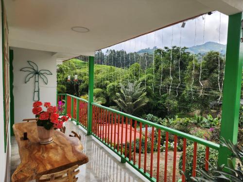 a balcony with a table and a view of the forest at Hotel Casa Quinta Salento in Salento