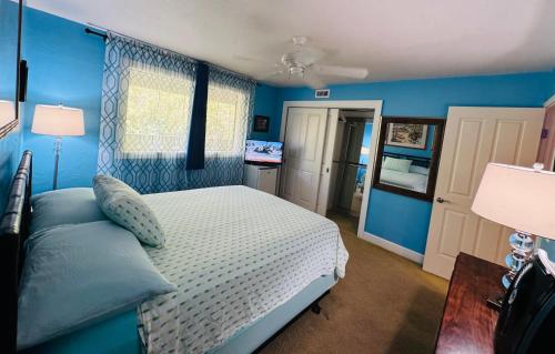 - une chambre avec des murs bleus, un lit et une table dans l'établissement Kona Magic Honu Room, à Kailua-Kona