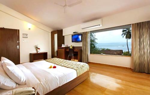 een slaapkamer met een groot bed en een groot raam bij The Hawaii Comforts in Panaji