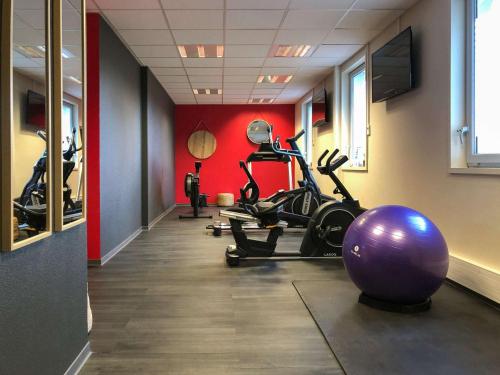 une salle de sport avec un grand ballon d'exercice violet dans l'établissement Ibis Saint-Genis-Pouilly Genève, à Saint-Genis-Pouilly