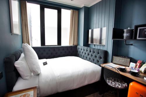 Habitación de hotel con cama, escritorio y ventana en The Dean Dublin, en Dublín