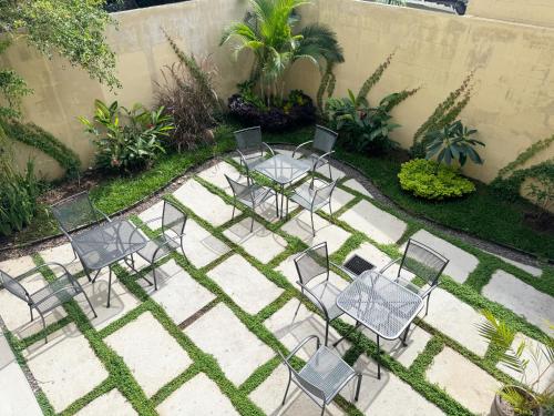 um grupo de cadeiras e mesas num jardim em Hotel Rimani em San Salvador