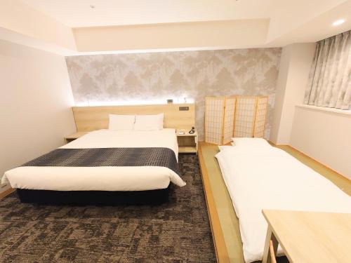 a hotel room with two beds and a window at Narita Tobu Hotel Airport in Narita