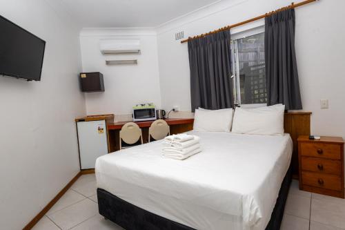 Tempat tidur dalam kamar di Gosford Inn Motel