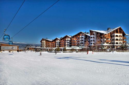 een gebouw in de sneeuw met een skilift bij Kempinski Hotel Grand Arena Bansko in Bansko