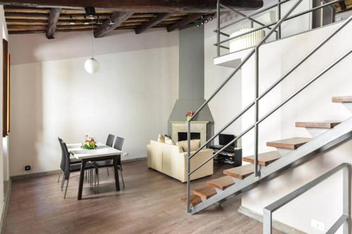 a living room with a table and a staircase at Navona Rubens Lodge in Rome