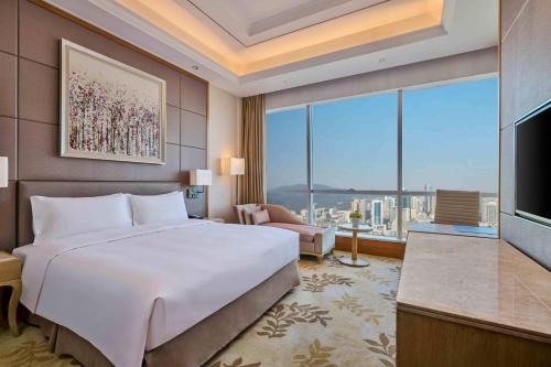 a bedroom with a large white bed and a large window at DoubleTree by Hilton Guangzhou-Free Shuttle Bus to Canton Fair Complex & Overseas Buyer Registration Services during Canton Fair Period in Guangzhou