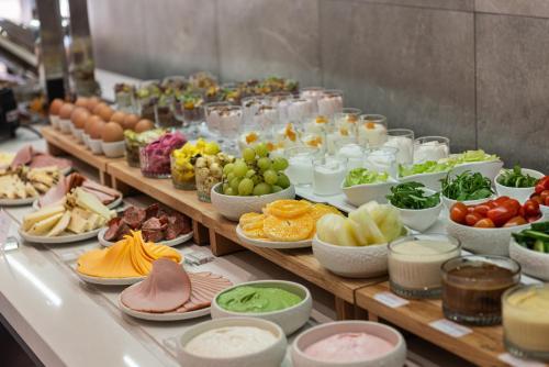 uma linha de buffet com muitos tipos diferentes de alimentos em Rise Urban Art Hotel em Larnaka