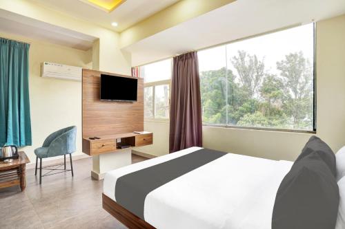 een slaapkamer met een bed en een groot raam bij Hotel O GAYATHRI METRO DELUXE in Bangalore